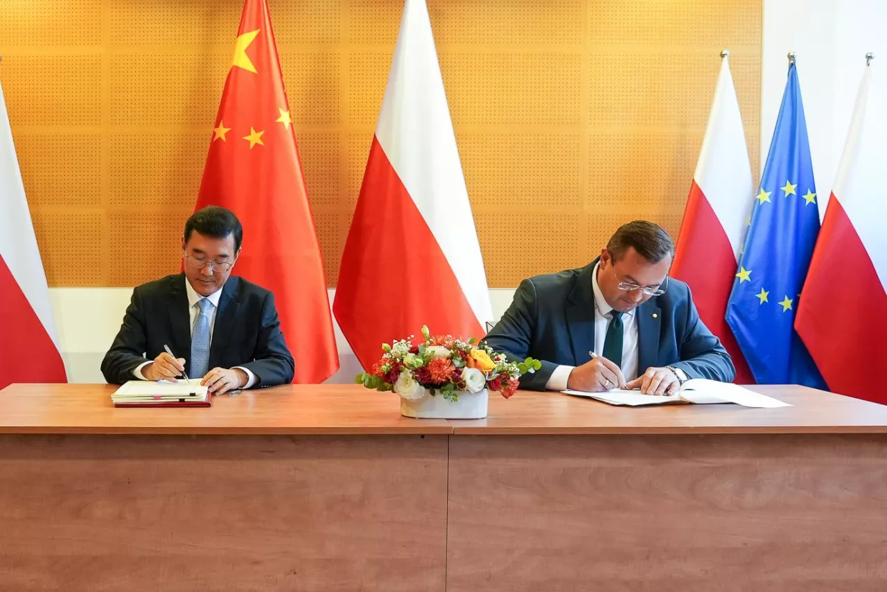 Stefan Krajewski, minister rolnictwa, oraz Zhao Zenglian, wiceminister Generalnej Administracji Celnej Chin, podpisujący porozumienie na tle flag państw