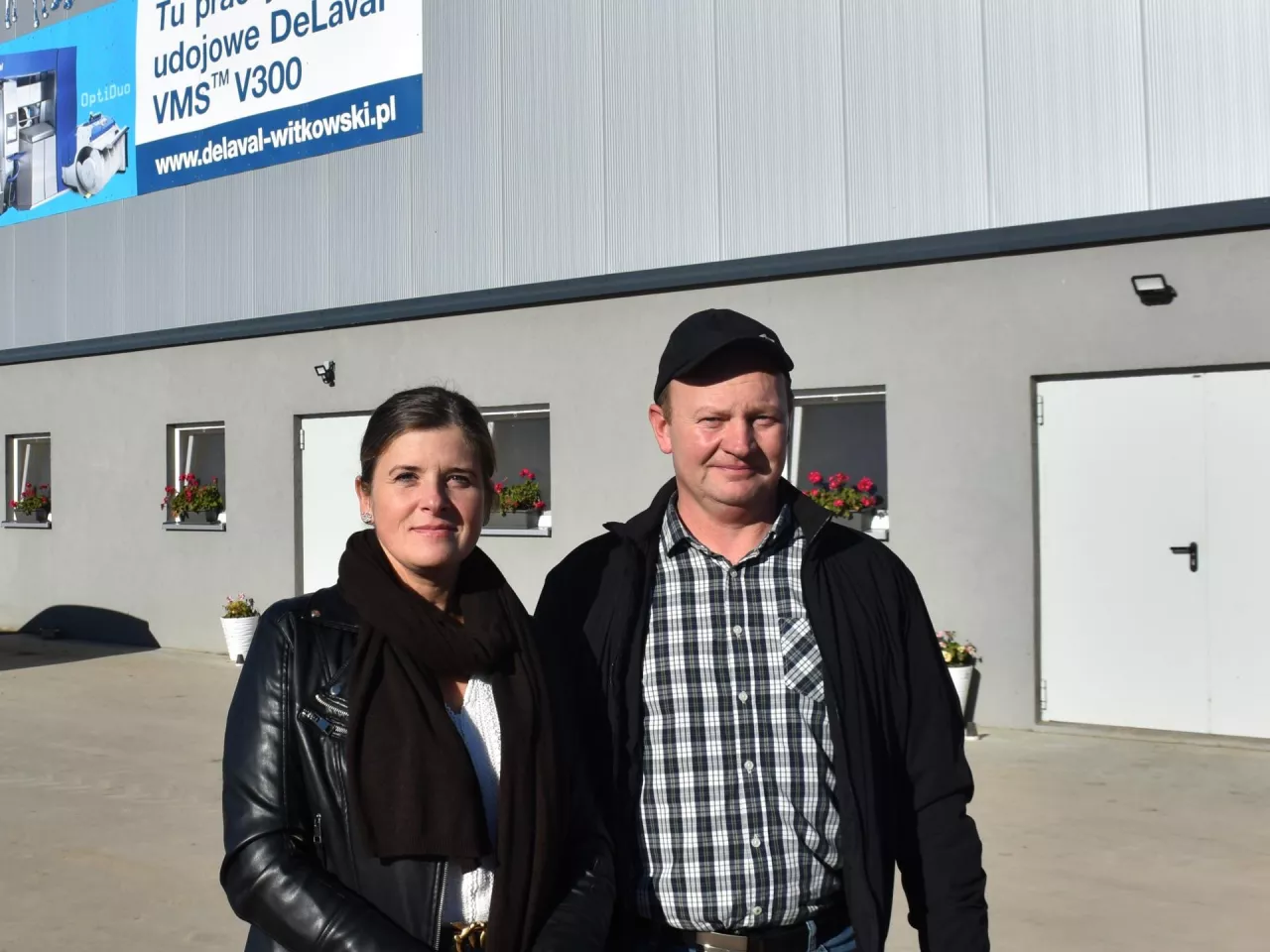 hodowcy stoją przed oborą